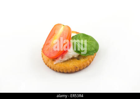 Piastra di snack di cracker conditi con pomodoro e basilico e ricotta Foto Stock