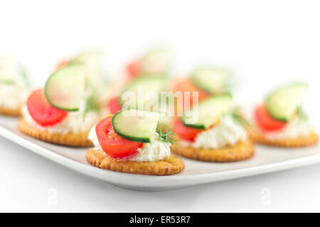 Piastra di snack di cracker conditi con pomodoro aneto di cetriolo e formaggio Foto Stock