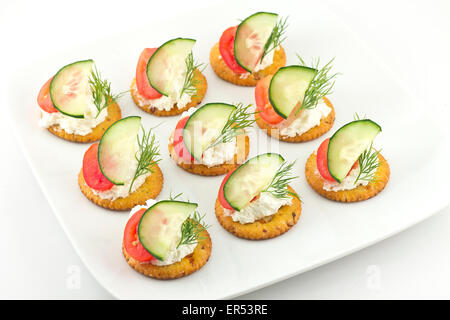 Piastra di snack di cracker conditi con pomodoro aneto di cetriolo e formaggio Foto Stock