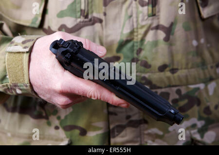 Uomo in combattimento fatiche azienda pistola automatica Foto Stock