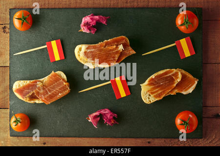 Lo spagnolo tapa con prosciutto, pane e bandiera spagnola brochettes Foto Stock