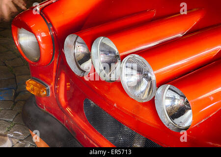 Quattro luci di ultracompatto che sta vecchia auto rossa con un sacco di luci Foto Stock