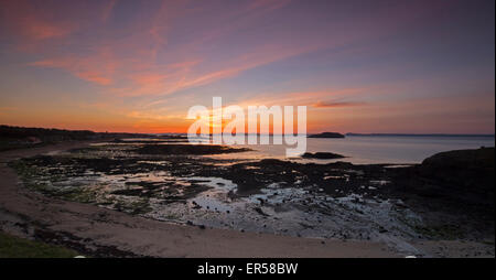Una vista costiera al tramonto a North Berwick in Scozia che si affaccia sulla baia con la bassa marea verso il Firth of Forth Foto Stock
