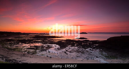 Una vista costiera al tramonto a North Berwick in Scozia che si affaccia sulla baia con la bassa marea verso il Firth of Forth Foto Stock
