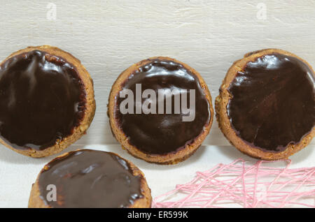 Biscotti con cioccolato fondente in piedi contro un pannello di legno Foto Stock