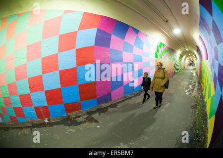 I viaggiatori passano attraverso il 900-piedi lungo 191st stazione della metropolitana tunnel di collegamento, recentemente decorate da artisti assunti dalla New York City dipartimento di Transportation giovedì, 21 maggio 2015. Gli artisti, COPE2, regina Andrea, Nick Kuszyk, Cekis e Jessie Unterhalter e Katey Truhn sono stati scelti in un processo competitivo dal punto. Il tunnel ha ricevuto recentemente aggiornato l'illuminazione a LED e con l'aggiunta dei dipinti murali è stata trasformata in una galleria d'arte. (© Richard B. Levine) Foto Stock