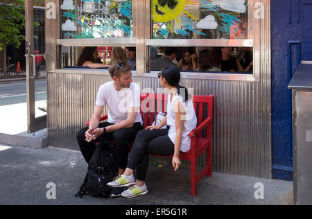 Coppia in attesa per un tavolo al di fuori del Café Habana ristorante Nolita nella città di New York Foto Stock