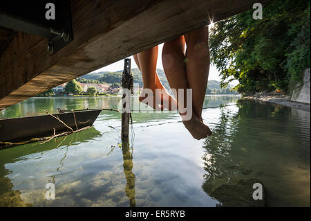 Due giovani donne seduto su di un molo al fiume Reno, Rheinfelden, Baden-Wuerttemberg, Germania Foto Stock
