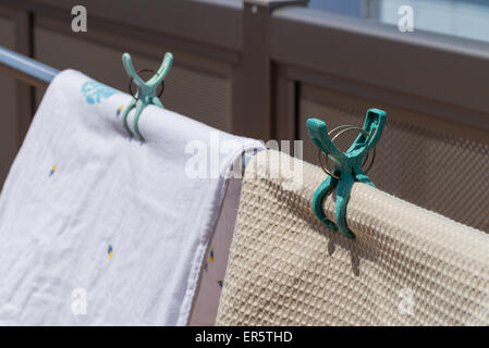 Alcuni asciugamani giacente fuori nel sole per asciugare, tenuto in posizione con una fascetta. Foto Stock