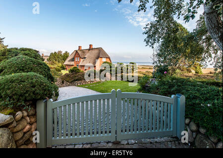 Con tetto di paglia house con il mare di Wadden in background, Kampen, Sylt, Schleswig-Holstein, Germania Foto Stock