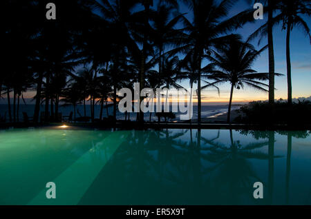 Piscina sotto le palme con vista mare al tramonto, Turtle Bay Hotel, Tangalle, South Coast, Sri Lanka Foto Stock