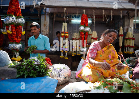 Donna stringing ghirlanda di fiori, Mercato Devaraja, Mysore, Karnataka, India Foto Stock