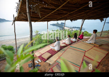 La meditazione prima del sorgere del sole sopra la spiaggia di Om, Gokarna, Karnataka, India Foto Stock