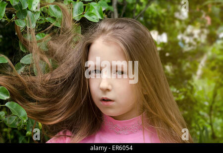 Bella ragazza costa vicino a un albero in estate Foto Stock