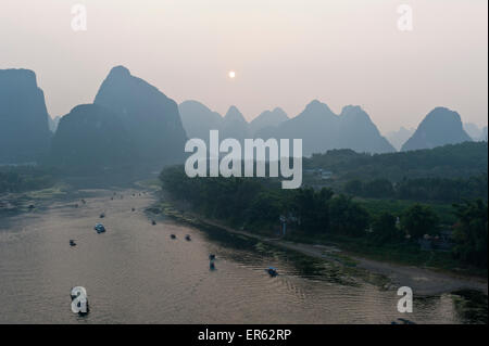 Vista dalla collina Yuping, atmosfera serale, tramonto e montagne carsiche, barche sul Fiume Li, Li Jiang, Yangshuo, vicino a Guilin Foto Stock