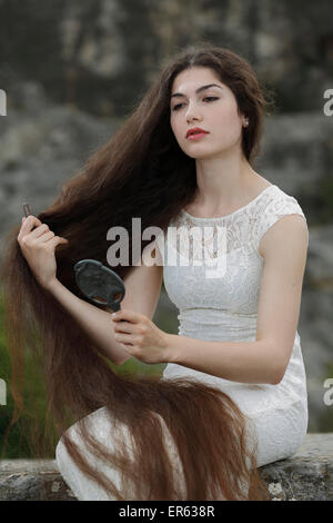 Promulgazione del dipinto Lady Lilith da Dante Gabriel Rossetti, ragazza in un abito bianco, pettinando i capelli e guardando in Foto Stock