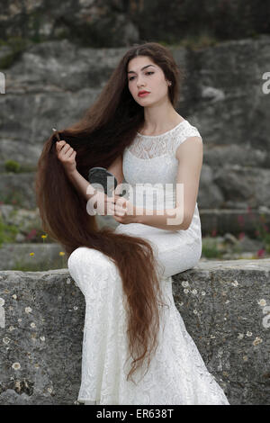 Promulgazione del dipinto Lady Lilith da Dante Gabriel Rossetti, ragazza in un abito bianco, pettinando i capelli e guardando in Foto Stock