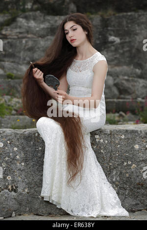 Promulgazione del dipinto Lady Lilith da Dante Gabriel Rossetti, ragazza in un abito bianco, pettinando i capelli e guardando in Foto Stock