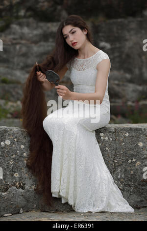 Promulgazione del dipinto Lady Lilith da Dante Gabriel Rossetti, ragazza in un abito bianco, pettinando i capelli e guardando in Foto Stock