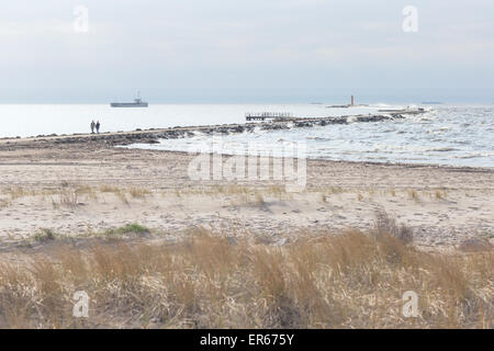 Coppia di giovani a piedi lungo il promontorio del faro nel Mar Baltico in una tempesta Foto Stock