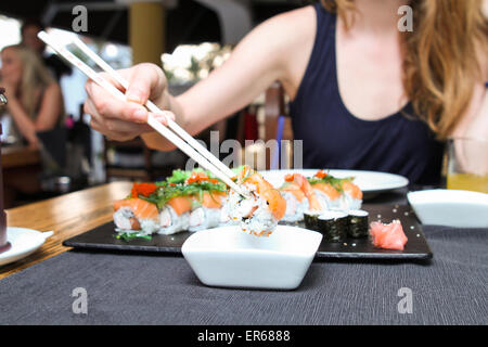 Donna di immersione a mano sushi in salsa di soia Foto Stock