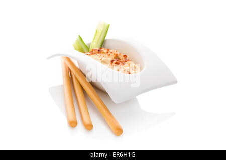 Hummus in bianco ciotola isolare su sfondo bianco. Il minimo di stile contemporaneo. Culinarie della cucina orientale. Foto Stock