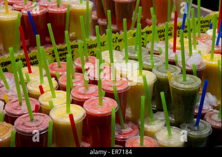 Succhi di frutta freschi sul visualizzatore in corrispondenza di un venditore in un mercato La Boqueria, Barcellona, Spagna Foto Stock