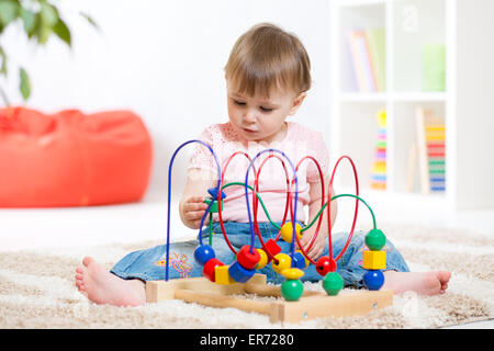 Kid bambina gioca con il giocattolo educativo in ambienti interni Foto Stock