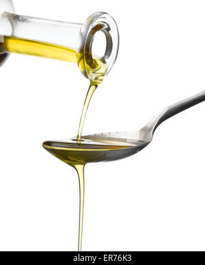 Olio d'oliva che scorre sopra un cucchiaio Foto Stock