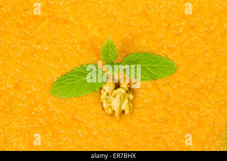 Sfondo della purea di zucca decorata con la menta piperita e la noce Foto Stock