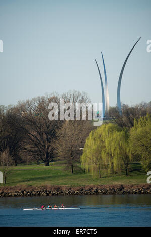 Monumento dell'Air Force con equipaggio di canottaggio a Washington DC | WASHINGTON DC — All'inizio della primavera appare il fogliame sugli alberi lungo il Potomac mentre passa un equipaggio di canottaggio. Il Monumento dell'Air Force degli Stati Uniti è visibile sullo sfondo ad Arlington, in Virginia. Le tre guglie in acciaio inossidabile del monumento rappresentano la manovra di volo "esplosione della bomba" e le scie di condensa degli Air Force Thunderbirds. Foto Stock