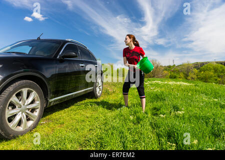 Persona di sesso femminile lavare la schiuma dal vetro auto. Donna sul  self-service di lavaggio di automobile. Esterno la pulizia del veicolo al  giorno di estate Foto stock - Alamy