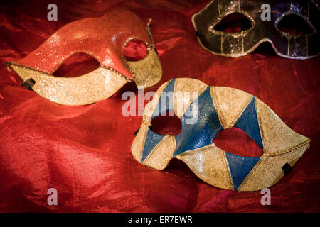 Tre maschere di carnevale su sfondo rosso Foto Stock