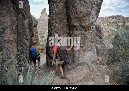 L uomo e la donna backpackers esplorare le formazioni rocciose a Fremont sella sul famoso sentiero Peralta nella superstizione Wilderness Area, Tonto National Forest vicino a Phoenix, Arizona, novembre 2011. Foto Stock