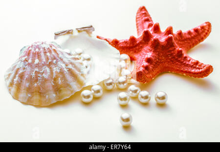 Scattering perle bianche in conchiglia e seastar Foto Stock