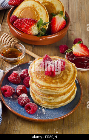 Piccoli pancake con frutti di bosco e di sciroppo. Vista superiore Foto Stock