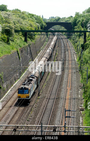 Treno merci sulla linea principale della costa occidentale a taglio Roade, Northamptonshire, Regno Unito Foto Stock