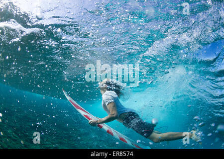 Vista subacquea di un surfista duck immersione sotto un'onda Foto Stock