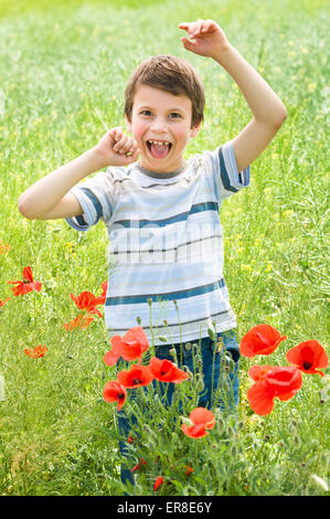 Ragazzo in fiore rosso papavero prato divertirsi Foto Stock