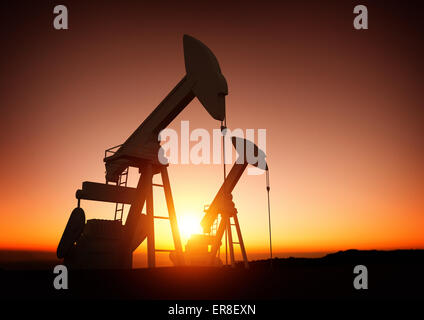 Olio e industria energetica. Un campo di pompe olio contro un tramonto. I prezzi del petrolio, energia e materie prime economiche. Foto Stock