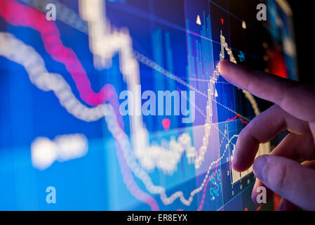 Un lavoratore cittadino analizzando il mercato azionario i dati su un monitor. Foto Stock