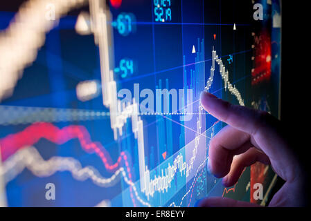 Un lavoratore cittadino analizzando il mercato azionario i dati su un monitor. Foto Stock
