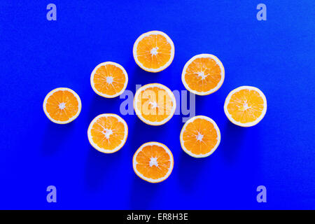 Direttamente sopra il colpo di fettine di arancia disposte a forma di diamante su sfondo blu Foto Stock