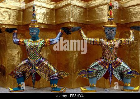 Bangkok, Thailandia: Due demon Kinnaree Khong ballerini alla base di una golden Chedi di Wat Phra Kaeo nel Palazzo Reale composto Foto Stock