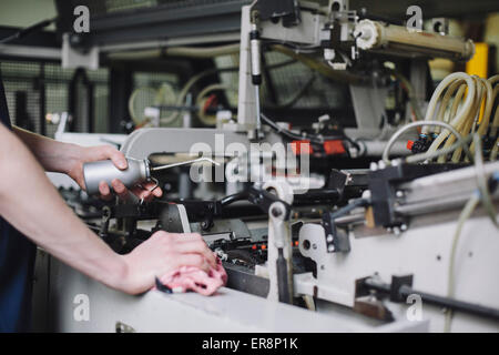 Immagine ritagliata del lavoratore manuale macchina di lubrificazione in fabbrica Foto Stock