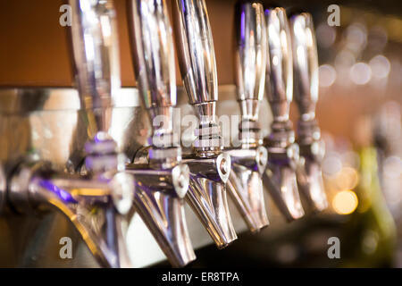 Camuffati shiny birra /vino rubinetti in una riga Foto Stock