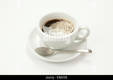 Nero caffè nella tazza bianca e piattino con cucchiaio isolato su uno sfondo bianco Foto Stock