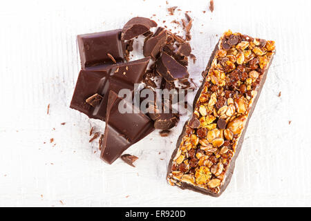 Granola bar con cioccolato bianco su sfondo di legno Foto Stock