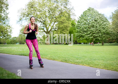 Giovane donna di pattinaggio nel parco Foto Stock