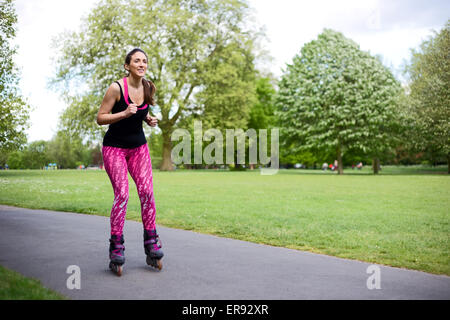 Giovane donna di pattinaggio nel parco Foto Stock